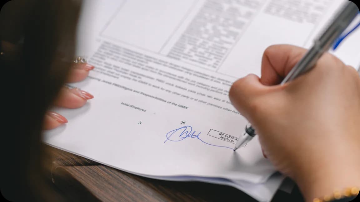 Hands signing employment contract